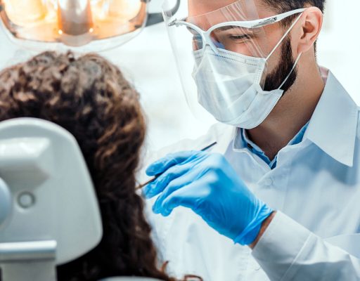 Dentist working in dental clinic with patient in the chair.
